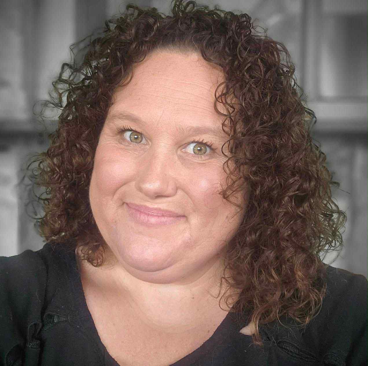 A profile photograph of a woman with curly hair.