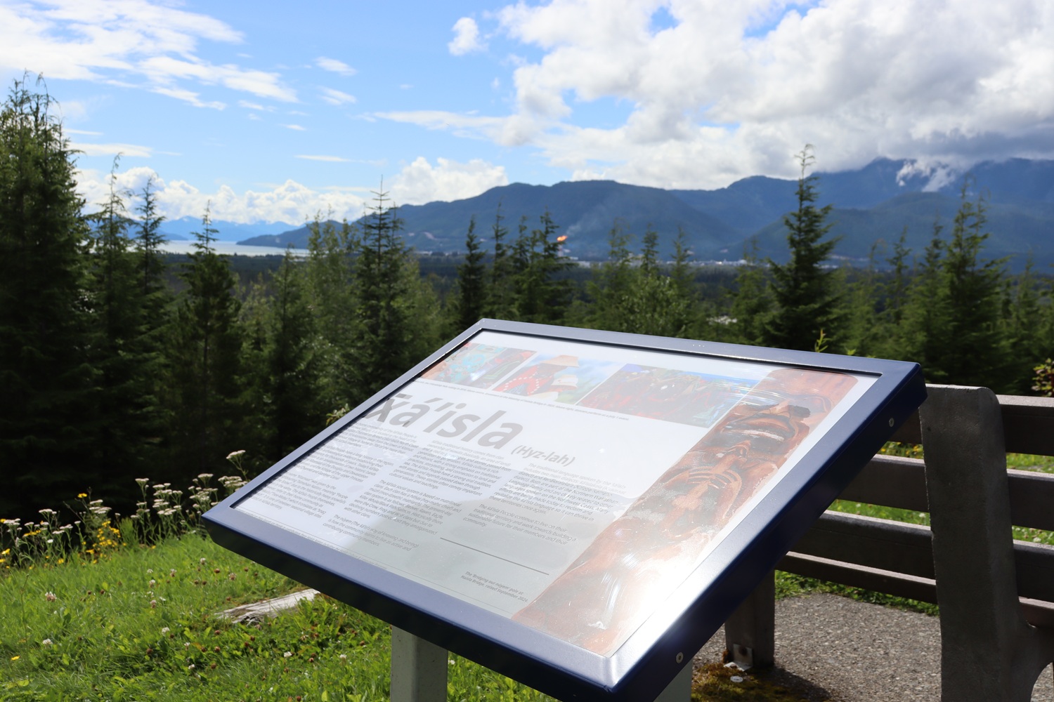 An information panel in a nature park overlooking mountains.