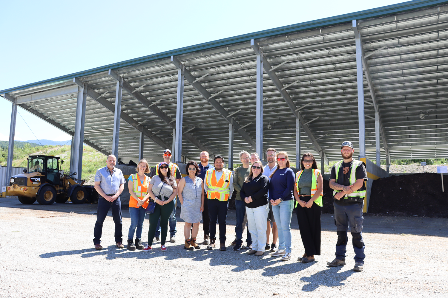 A group of people in front of a metal roofed building.